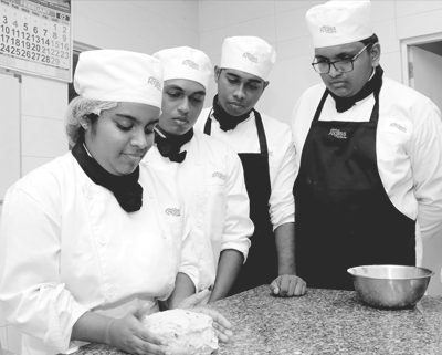 Baking students prepare a dough in the bakery.